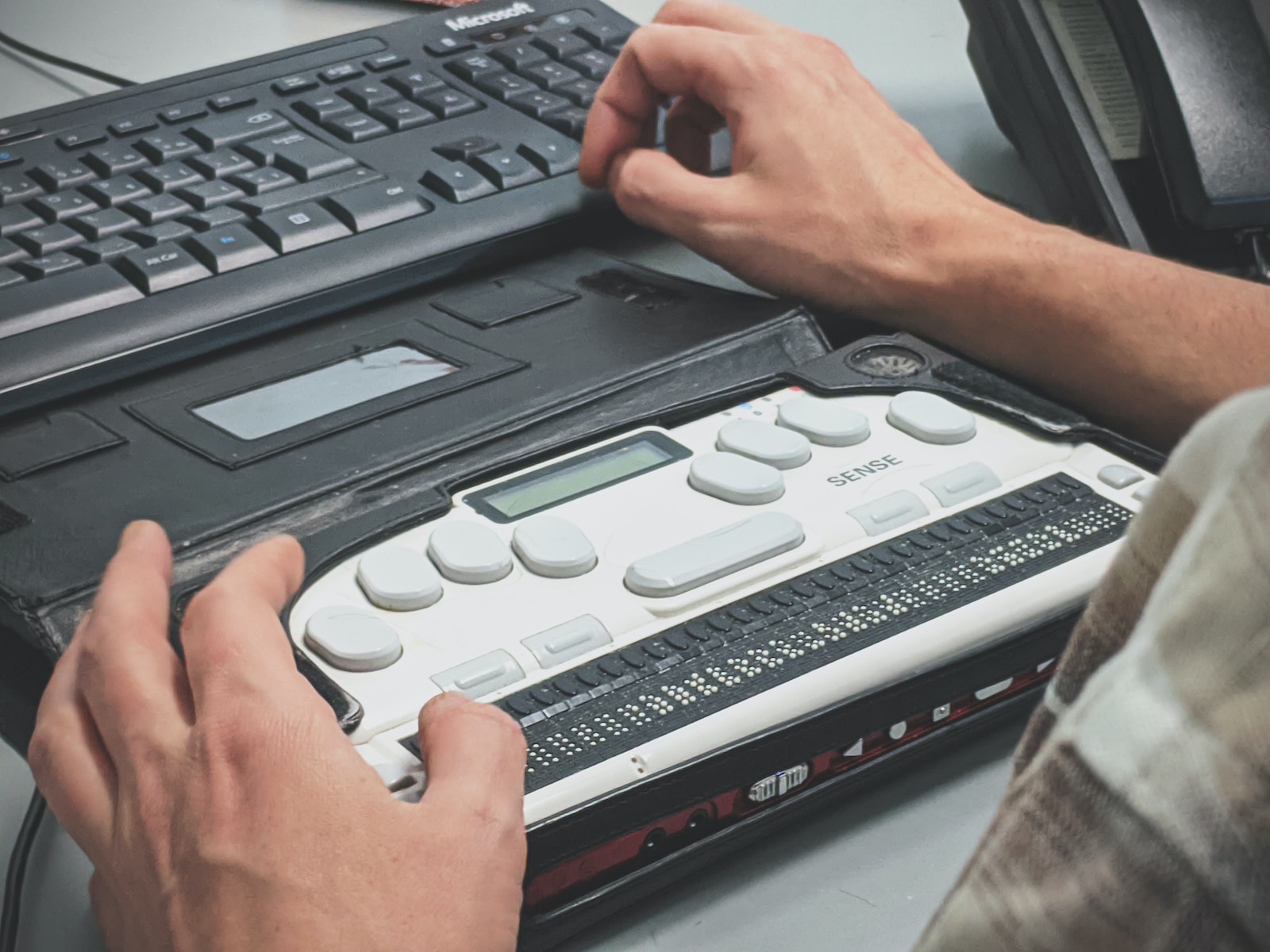 person holding pencil near laptop computer